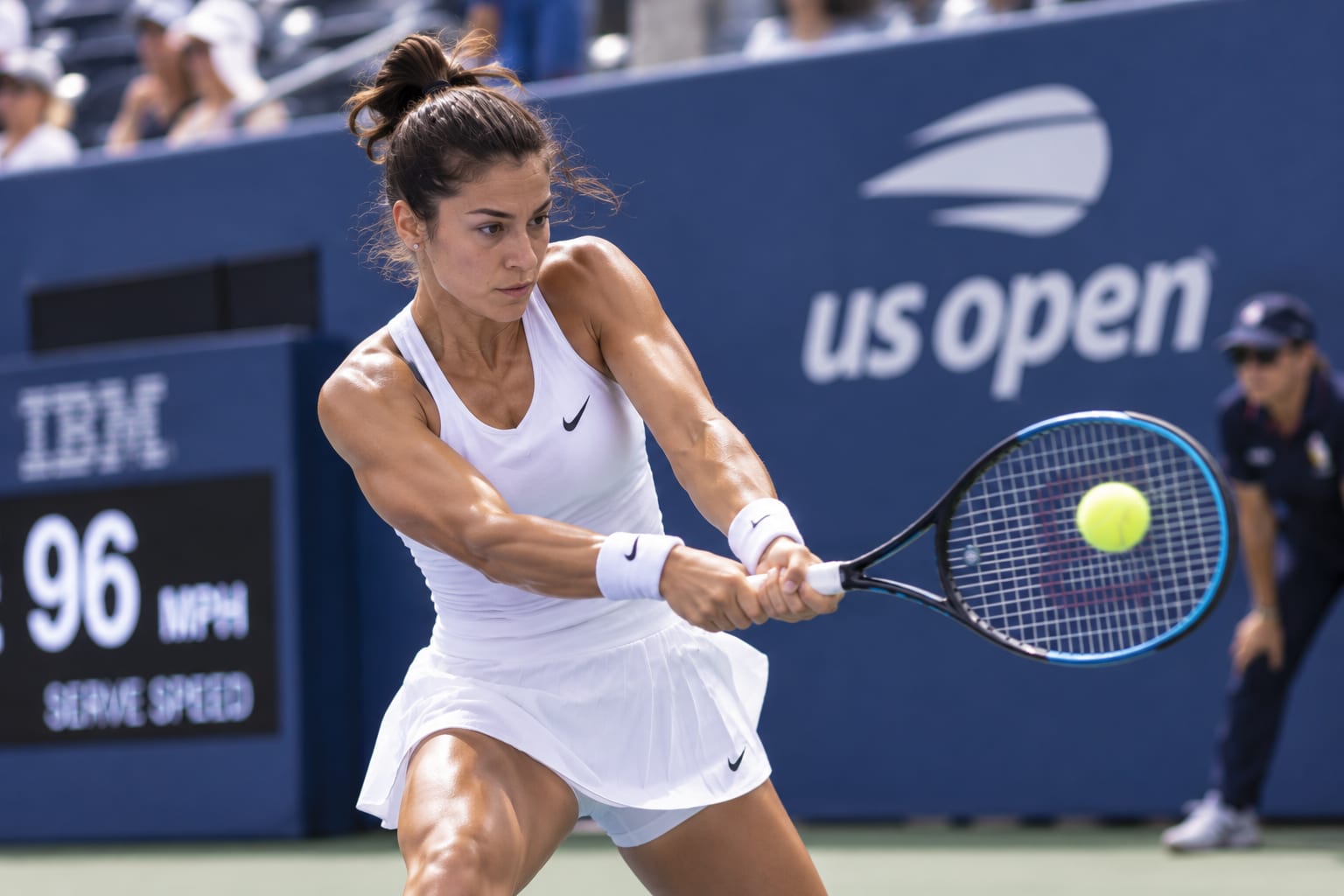 Tennis player returning a ball during a stadium match